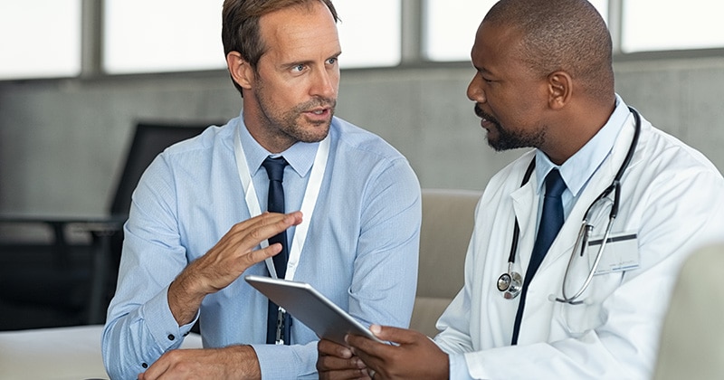Healthcare professionals exchanging patient data digitally